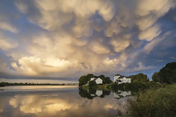 Fantastisk dramatiska mammatus moln bildas över sjön landskap — Stockfoto