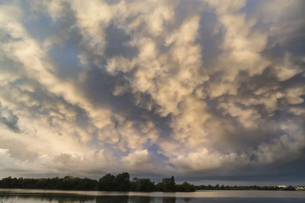 Fantastisk dramatiska mammatus moln bildas över sjön landskap — Stockfoto