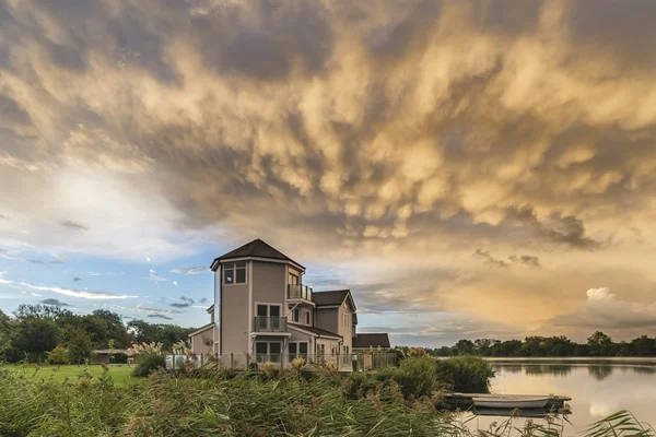 Bela formação de nuvens de mamíferos sobre a paisagem do lago imediata — Fotografia de Stock