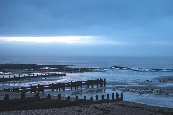 Freddo paesaggio alba spiaggia invernale con bassa marea con sk drammatico — Foto Stock