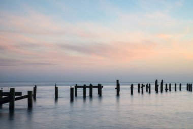 Stunning peaceful sea landscape of old derelict pier foundations clipart
