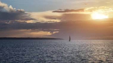 Okyanus canlı renkli günbatımı sırasında yalnız yelkenli tekne