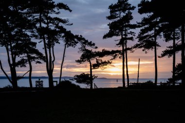 Canlı kış günbatımı sırasında sahilinde çarpıcı siluet