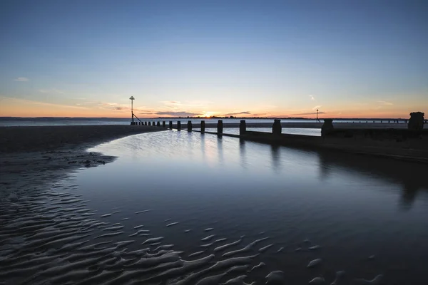 Bonita vibrante Primavera pôr do sol exposição longa praia paisagem — Fotografia de Stock