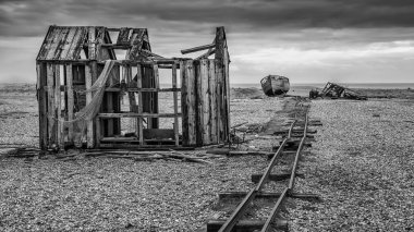 Terk edilmiş Balık tutma hut ve shingle Plajı fırtınalı Wi sırasında on rails
