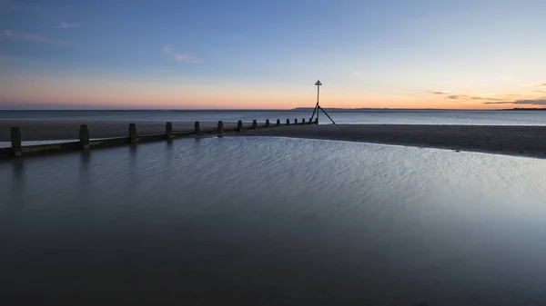 Mooie levendige voorjaar zonsondergang lange blootstelling strand landschap — Stockfoto