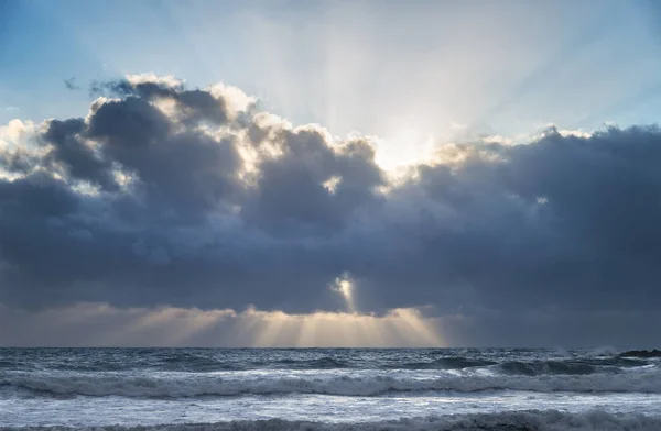 Patrik moln formationer över havet vid solnedgången med precuspular Sol — Stockfoto