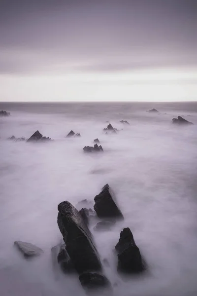 Hermosa imagen de paisaje de larga exposición de mar sobre rocas durante —  Fotos de Stock