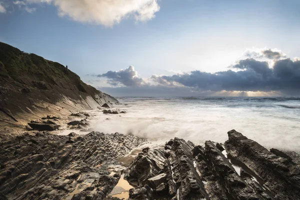 Prachtige kleurrijke levendige zonsondergang over rotsachtig strand met lange exp — Stockfoto