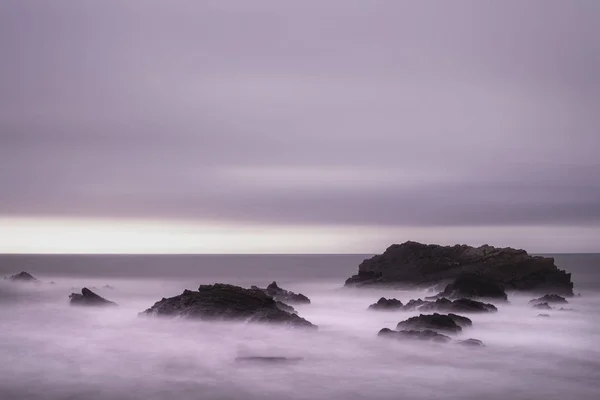 Güzel uzun pozlama peyzaj görüntüsünü deniz sırasında kayalar üzerine — Stok fotoğraf