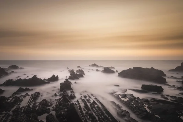 Hermosa imagen de paisaje de larga exposición de mar sobre rocas durante —  Fotos de Stock