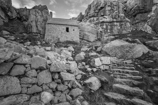 Stunning black and white landscape image of St Govan\'s Chapel on