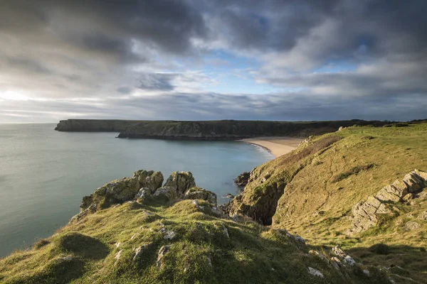 Wspaniały, żywy obraz krajobraz wschód słońca, plaża Barafundle Bay na P — Zdjęcie stockowe