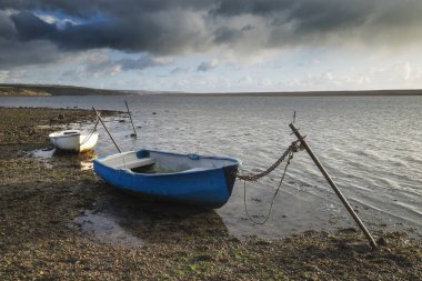 Pire içinde demirleyen teknelerin güzel canlı günbatımı manzara resim