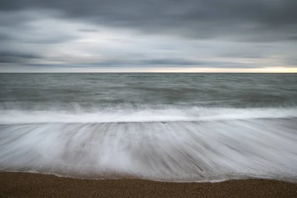 Beautiful vibrant sunset landscape image of Burton Bradstock gol — Stock Photo, Image