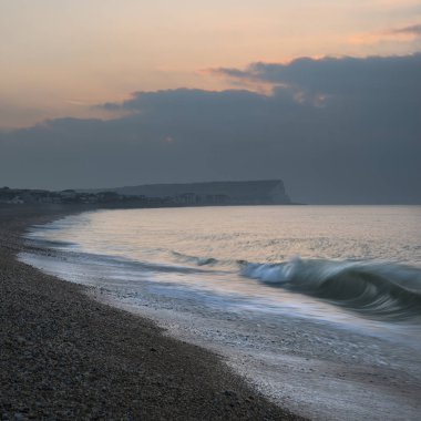 Güzel canlı gündoğumu plaj manzara dalgalar üzerinde kırma ile