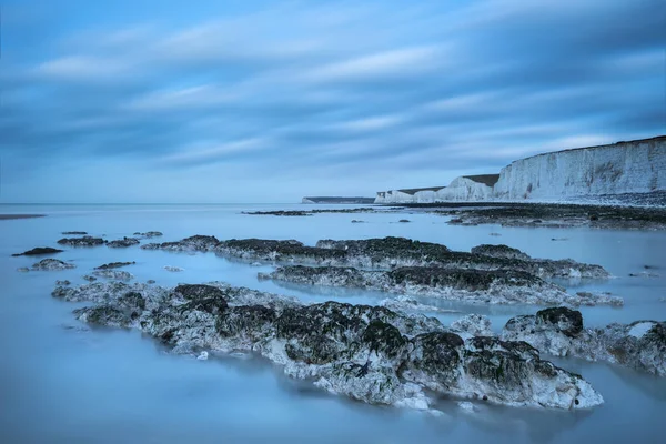 Stunning long exposure landscape image of low tide beach with ro — Stock Photo, Image