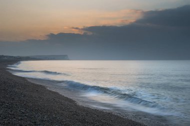 Güzel canlı gündoğumu plaj manzara dalgalar üzerinde kırma ile