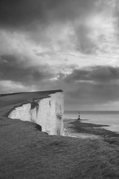 Stunning black and white landscape image of Beachy Headt lightho