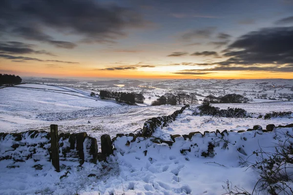 Stunning Winter sunset over snow covered Winter landscape in Pea