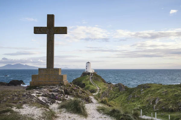 Weergave van Keltisch kruis op Angelsey met Twr Mawr vuurtoren in bac — Stockfoto