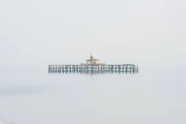 Bellas artes minimalista imagen de muelle abandonado permanece en el mar durante — Foto de Stock