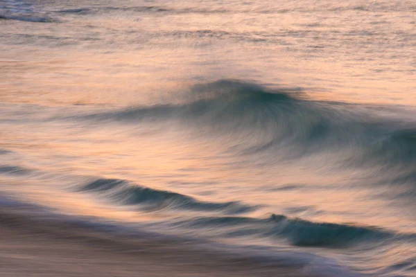 Ohromující obraz krajiny zářivé svítání Porthcurno Beach na — Stock fotografie