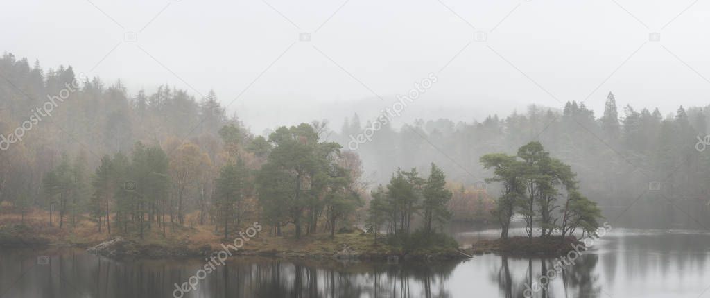 Beautiful mody Autumn Fall landscape of woodland and lake with m