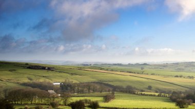 Beautiful Peak District Winter landscape of late afternoon sun a