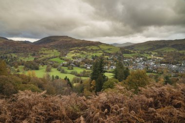 Loughrigg 'den sonbahar manzarası Keswick' in üzerinden karamsar gökyüzü ile dağ arka planına doğru esiyor.