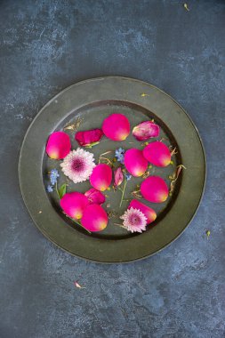 Düz bir şekilde uzanmış çiçek yapraklarının romantik mahsul görüntüsünün kırsal ve yıpranmış arka planında hayat devam ediyor.