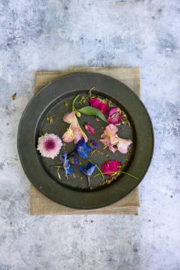 Düz bir şekilde uzanmış çiçek yapraklarının romantik mahsul görüntüsünün kırsal ve yıpranmış arka planında hayat devam ediyor.