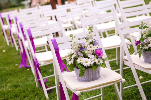 Witte bruiloft stoelen met paarse lint — Stockfoto