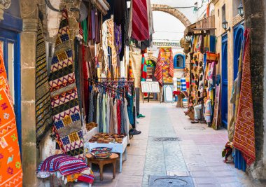 Fas halıları ve giysileri Essaouira, Fas 'ın dar sokaklarında satılık.