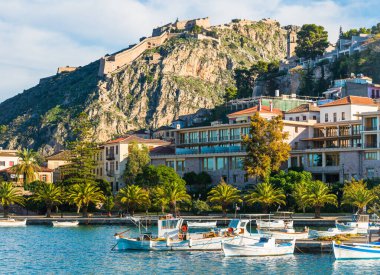 Yunanistan 'ın Nafplio kentinde limanda tekneler ve kayalık tepede Palamidi kalesi bulunuyor