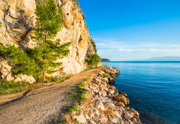 Wanderweg entlang der Meeresküste mit blauem Wasser bei Sonnenuntergang in Griechenland — Stockfoto