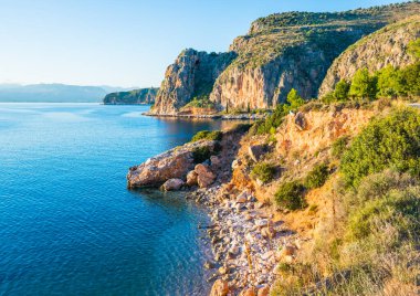 Nafplio kasabası yakınlarında kayalık kayalıkları ve çakıl taşlı plajları olan Yunan kıyıları