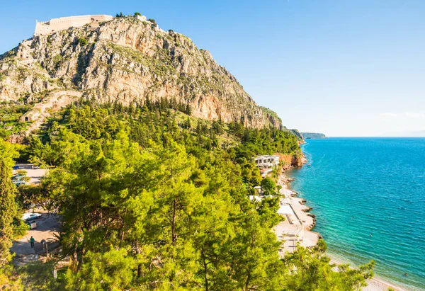 Blick auf die Festung Palamidi in Nafplio auf felsigem Hügel und schönem Strand mit blauem Wasser in Griechenland — Stockfoto