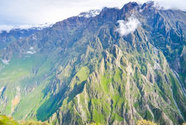 Colca Kanyonu, Peru 'da kayalık kayalıkları ve küçük bulutları olan bir dağ sırası.
