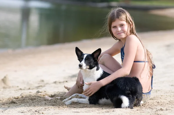 Pretty girl with her dog on the beach — Stock Photo, Image