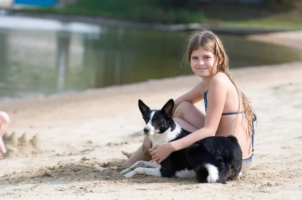 Pretty girl with her dog on the beach — Stock Photo, Image