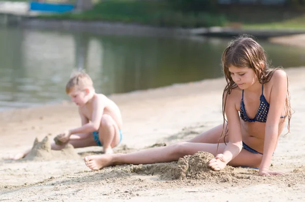 Двое детей играют с песком — стоковое фото