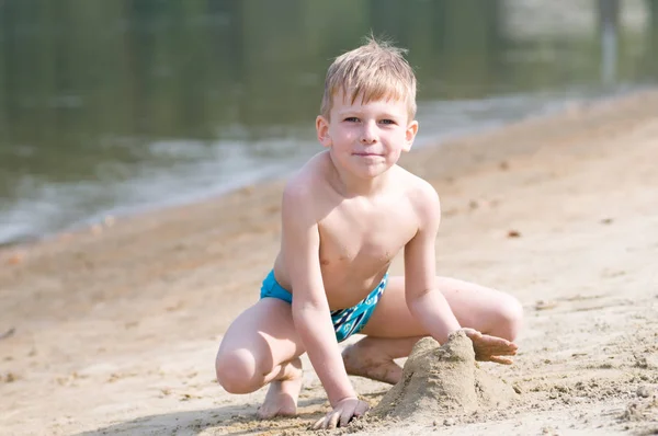 Niño en la playa juega con la arena — Foto de Stock
