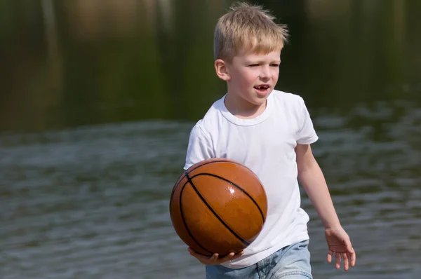 Chlapec s míčem basketbal v jeho rukou — Stock fotografie