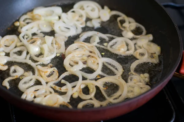 Onion is frying on pan red color — Stock Photo, Image