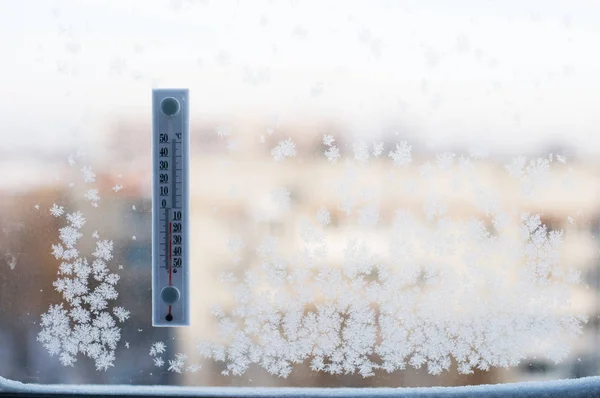 Thermometer am Winterfenster mit Frost lizenzfreie Stockfotos