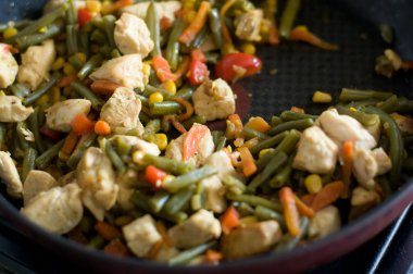 Tavuk eti ve kırmızı tavada pişirme sebze