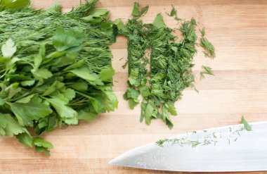 Dereotu ve maydanoz kesme tahtası üzerinde