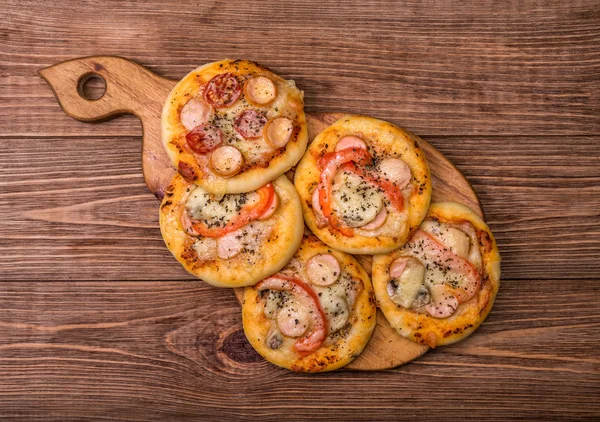 Mini pizzas on wooden board. — Stock Photo, Image