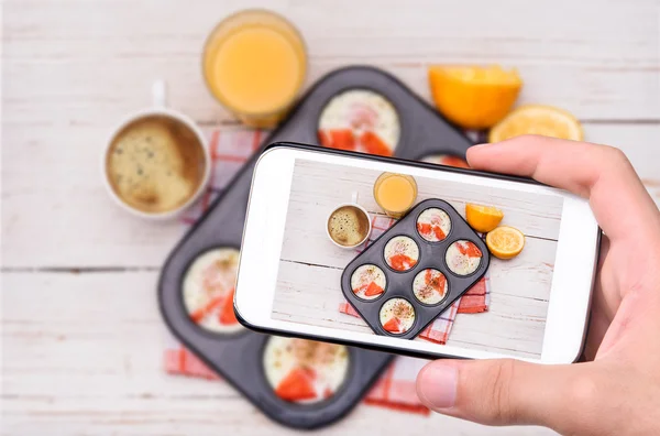 Mani che scattano foto muffin stagno uova al forno con smartphone . — Foto Stock